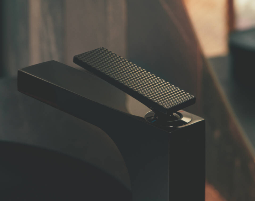 Close-up of AXOR MyEdition basin mixer in matte black with textured diamond-cut leather or metal cover plate
