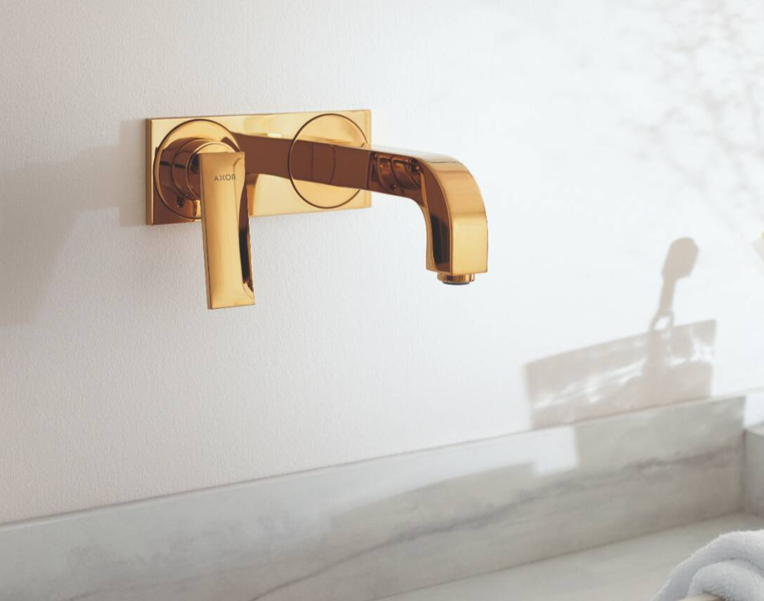 AXOR wall-mounted single lever washbasin mixer in polished gold finish with rectangular backplate