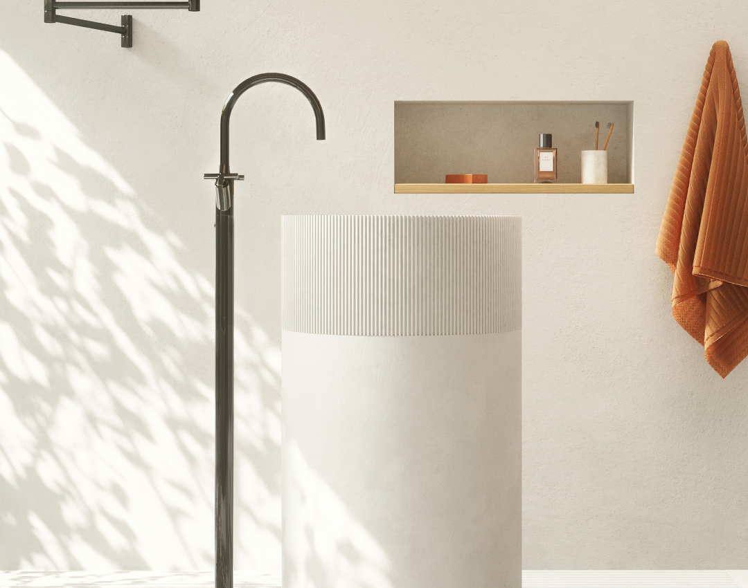 Dornbracht Tara floor-standing matte black basin mixer with a white fluted pedestal washbasin and minimalist wall niche