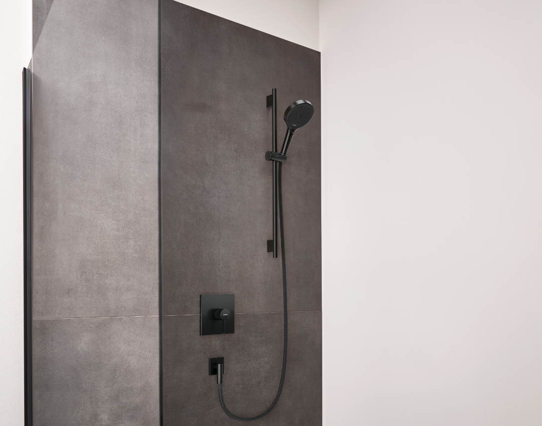 Hansgrohe matte black shower kit with adjustable slide rail and concealed thermostatic mixer. Minimalist shower design featuring industrial grey stone tiles and black bathroom brassware.