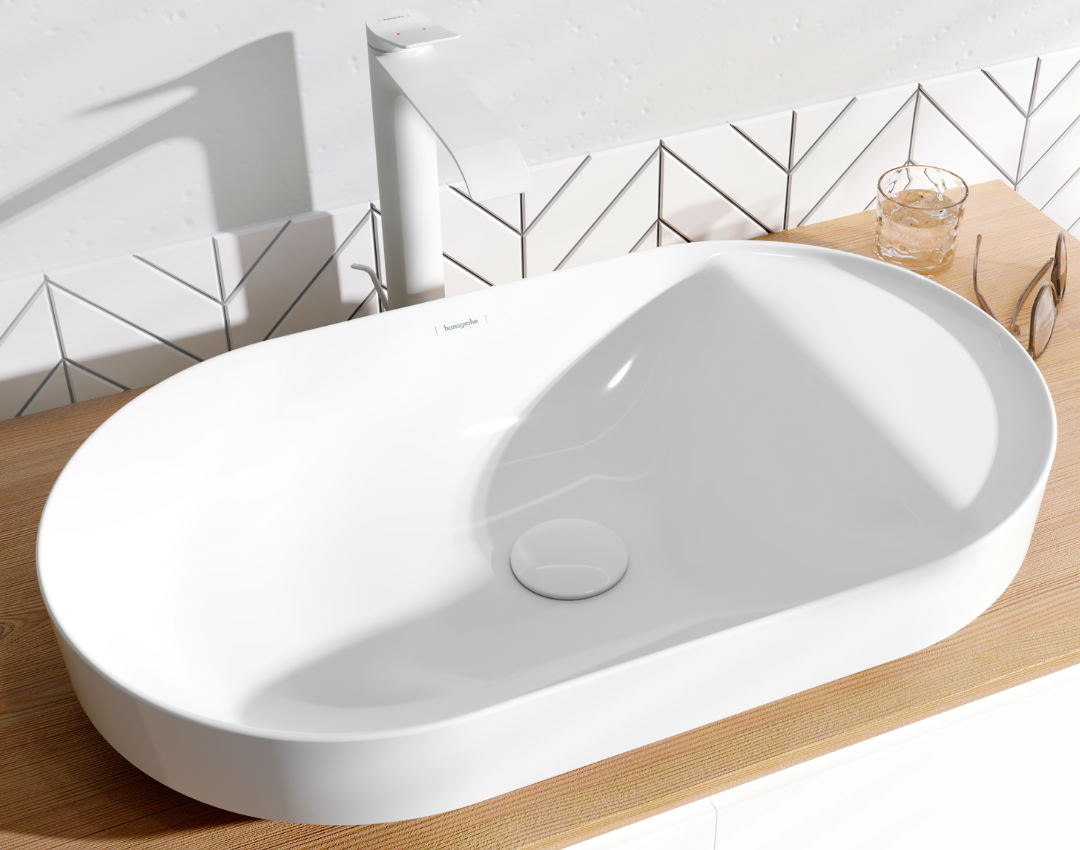 Oval white ceramic countertop washbasin by Hansgrohe, featuring a matching white tall mixer tap on a light wood vanity unit with geometric wall tiles.