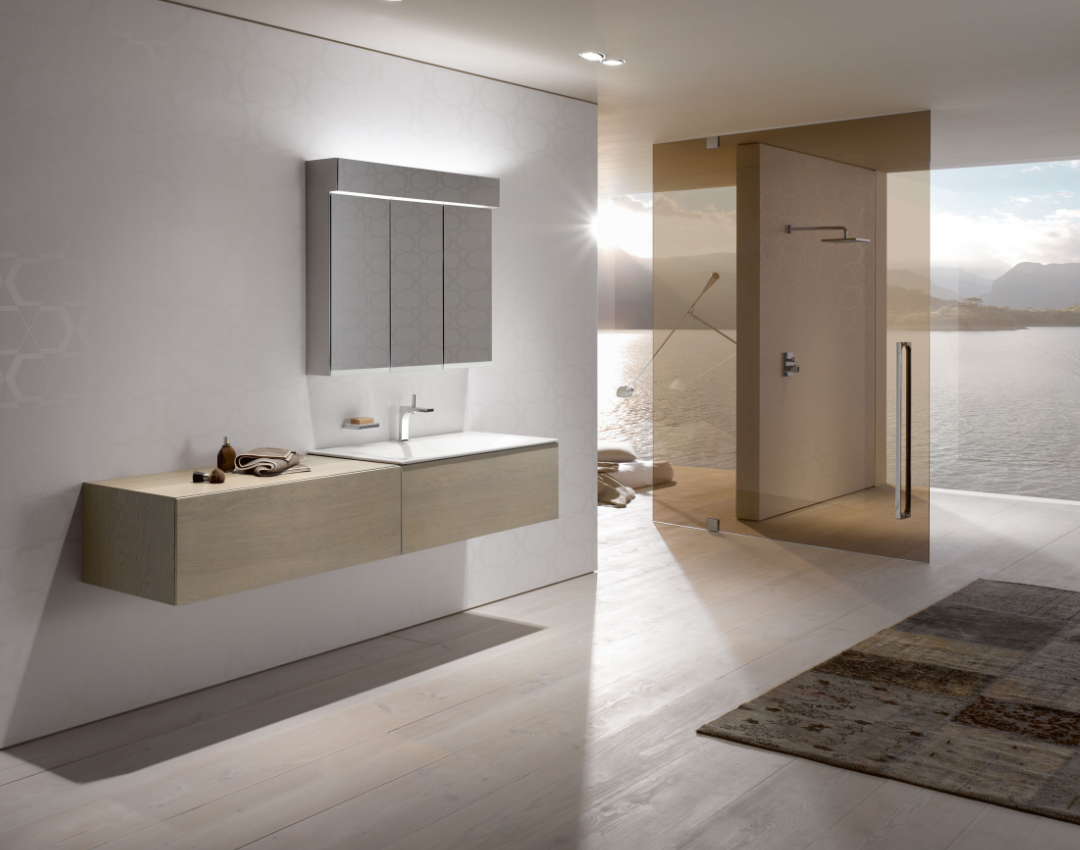Keuco Edition 400 light oak wall-hung vanity unit with integrated white washbasin, featuring a three-door illuminated mirror cabinet and a walk-in shower with tinted glass.