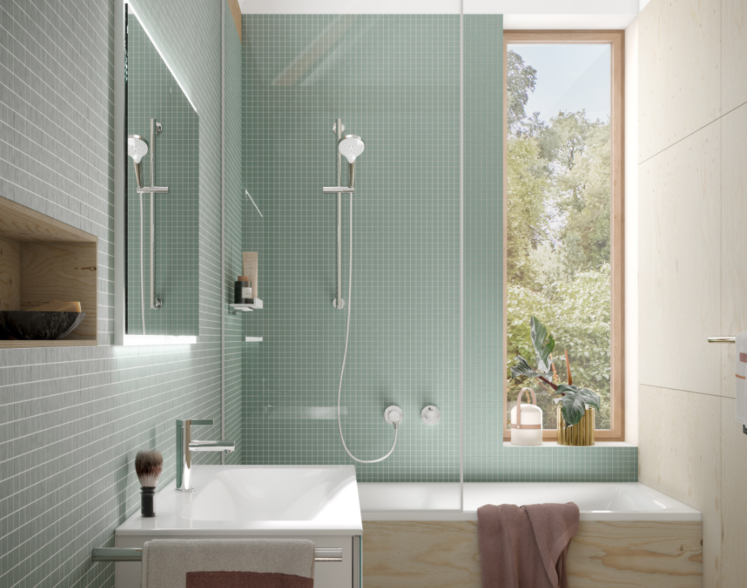 Modern small bathroom design featuring KEUCO Plan chrome shower kit and accessories. Includes a minimalist white vanity unit, space-saving shower-bath combination, sage green mosaic tiles, and light oak wood paneling.